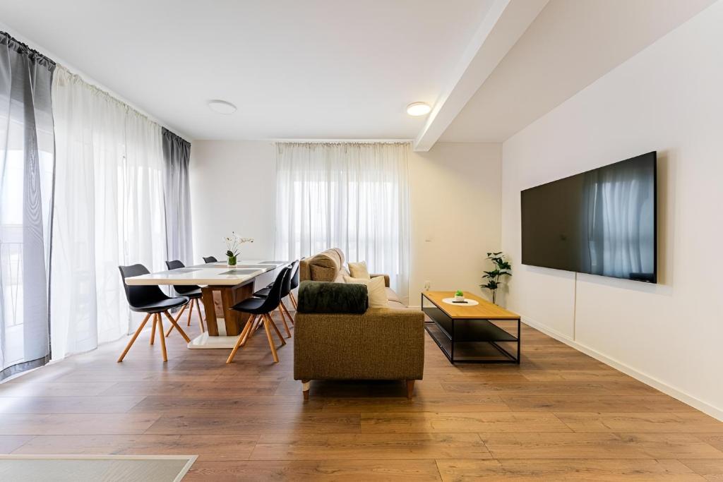 a living room with a table and a tv at Flex SelfCheckIns 99 - 2 Bedrooms - Parking - Loggia in Velika Mlaka