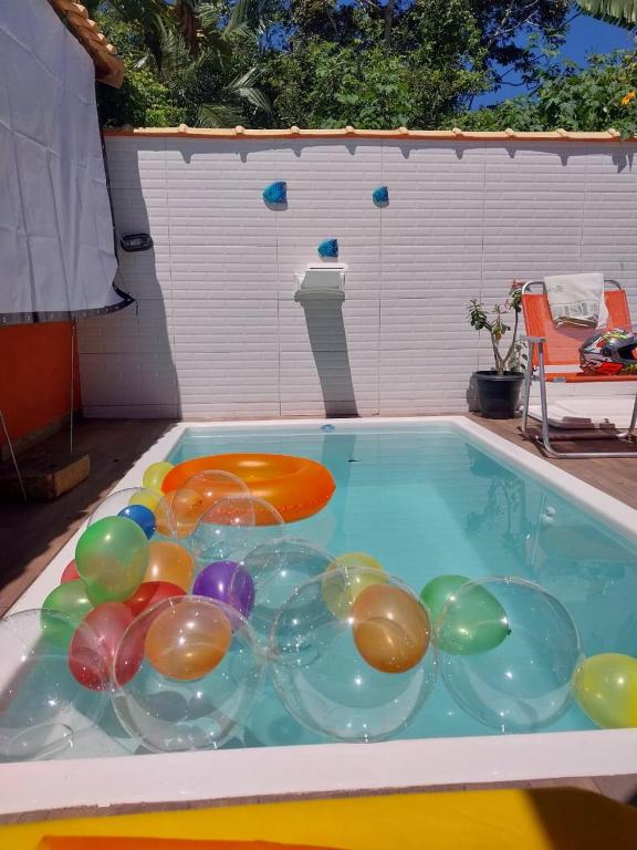 a pool with a bunch of balloons in the water at Casa de Praia no Condomínio Florestinha com 02 quartos in Tamoios