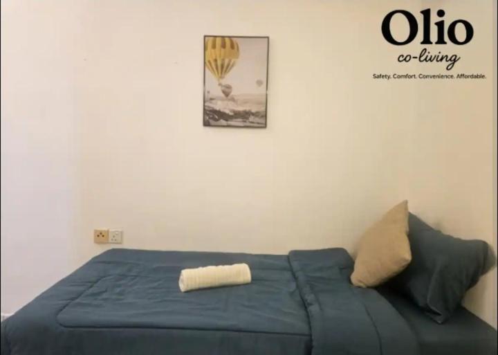 a bed in a room with a poster on the wall at Olio CoLiving Pudu Kuala Lumpur in Kuala Lumpur