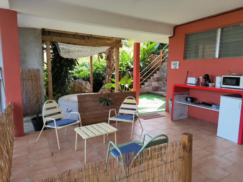 a patio with chairs and a table and a kitchen at studio Caraïbes in Les Trois-Îlets