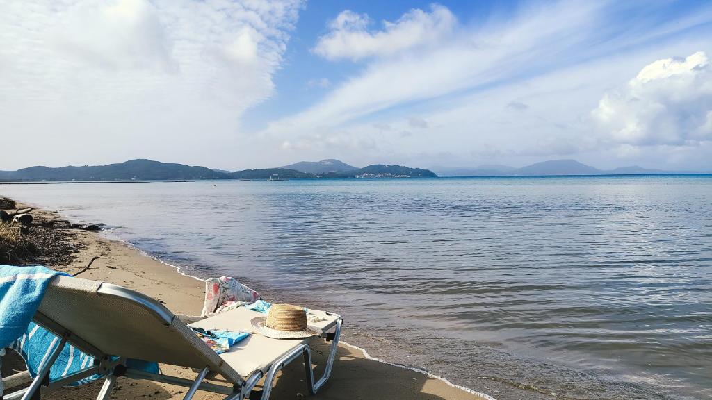a table and a chair sitting on the beach at Blue Pearl Molos in Mólos