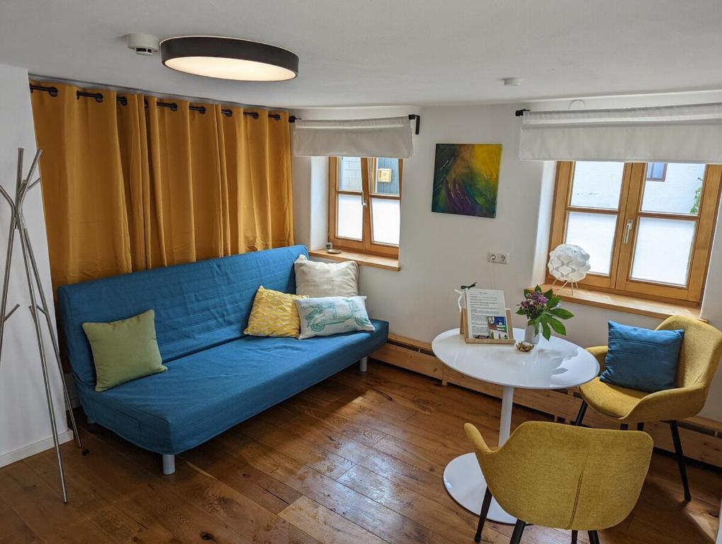 a living room with a blue couch and a table at Gemütliches, helles, voll ausgestattetes Apartment mit Terrasse in Waal