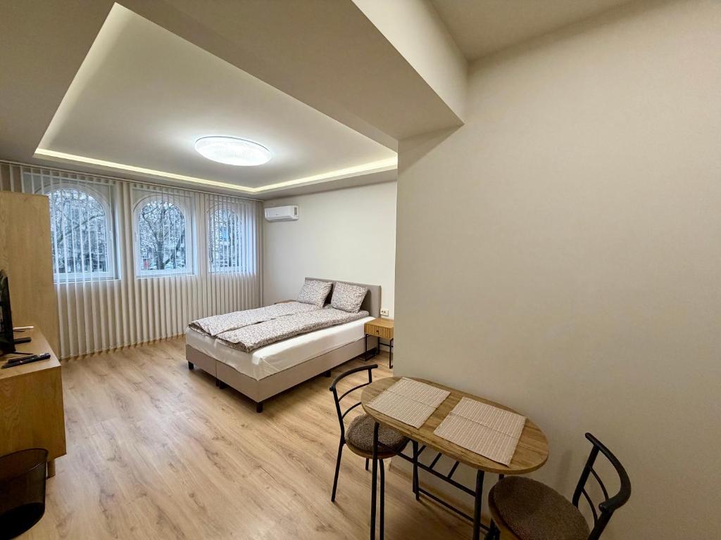 a bedroom with a bed and a table and chairs at Boutique Rooms Desi 1 in Pleven