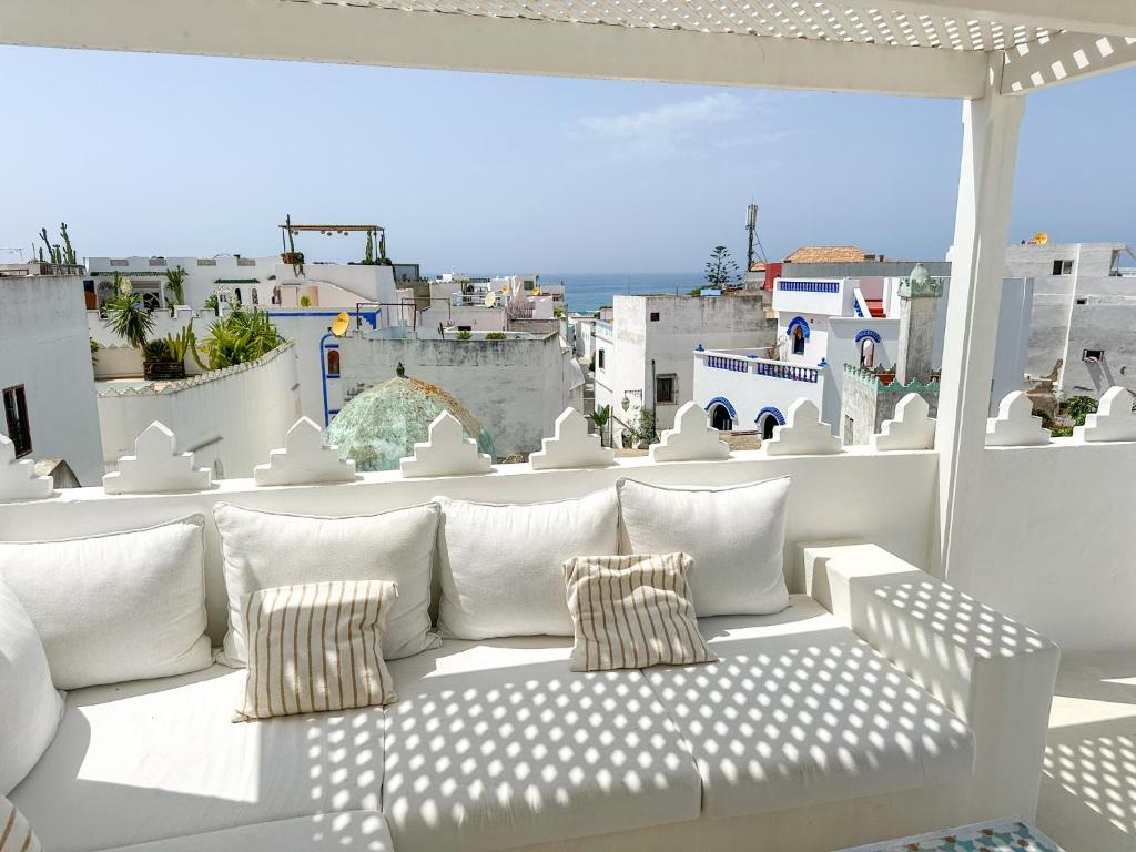 a white couch sitting on top of a balcony at Riad Olivia in Asilah