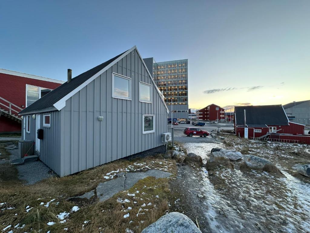 a small gray building in front of a parking lot at Uka Guesthouse Downtown in Nuuk