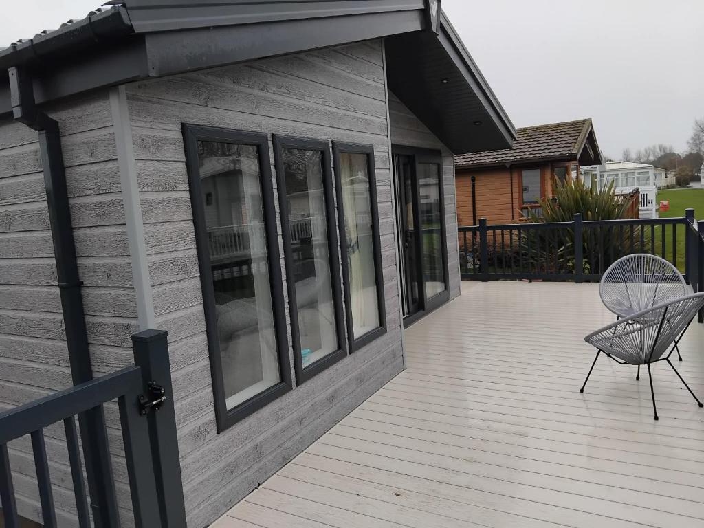 a deck with a chair on a house at Luxury 3 bed lodge, Skegness - East Coast Holidays in Winthorpe