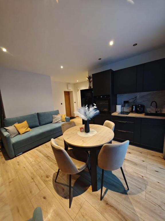 a living room with a couch and a table and chairs at Apartament WLK HOUSE in Gdynia