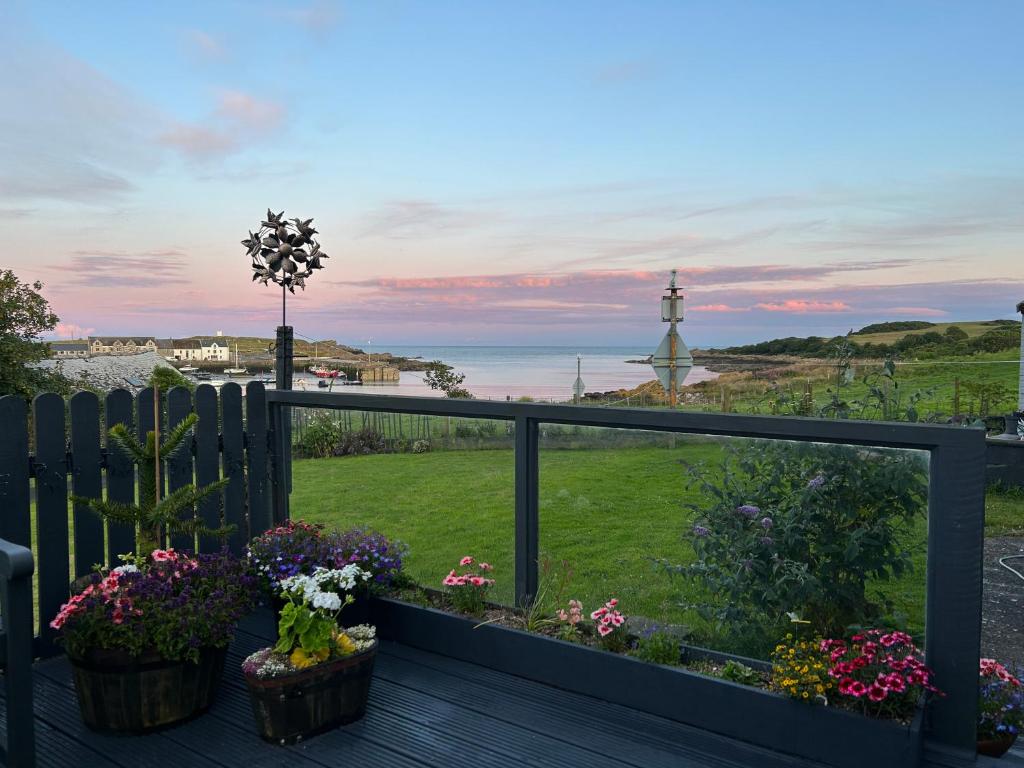 a balcony with flowers and a view of the ocean at Islecroft House Bed & Breakfast in Isle of Whithorn