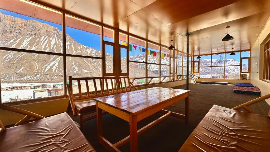 a room with a table and chairs and mountains at Piti khangpa in Kaza