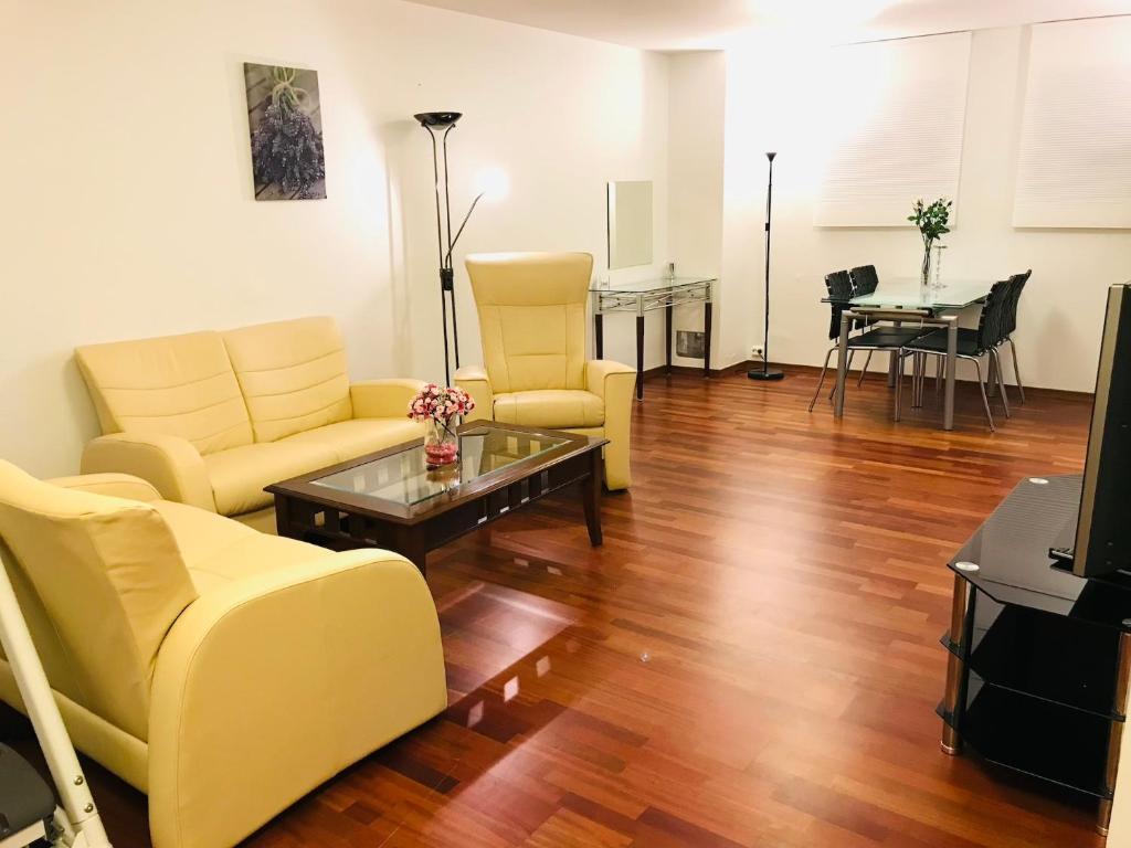 a living room with yellow furniture and a table at Hinna Apartment in Stavanger