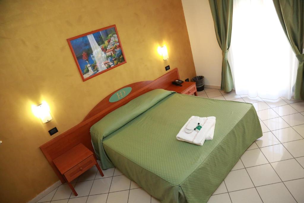 Un dormitorio con una cama verde con una toalla. en Hotel Dorè, en Milán