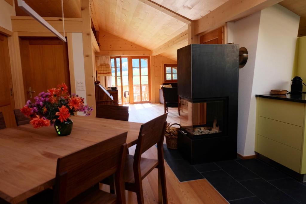 a kitchen and dining room with a table and a fireplace at Comfortable quiet apartement with great view in Diemtigen