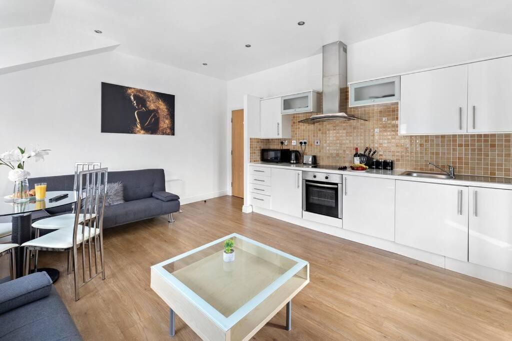 a kitchen and living room with a couch and a table at Newcastle City Centre Apartment in Newcastle upon Tyne