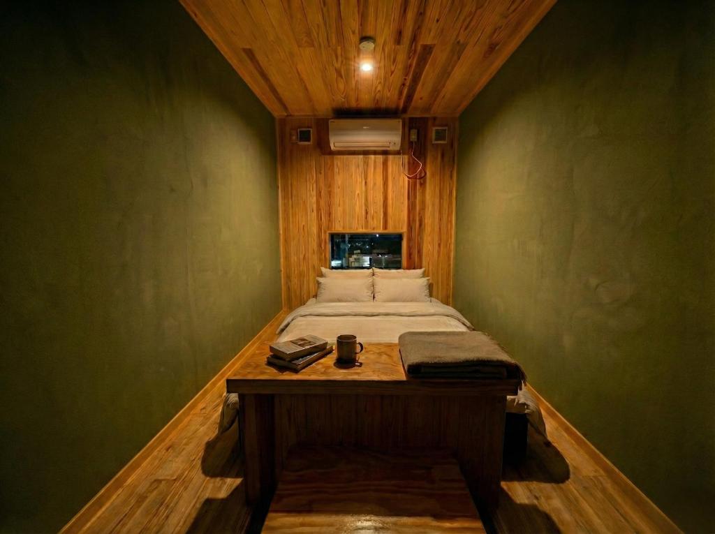 a small bedroom with a bed and a table at 山過HOTELs in Chino