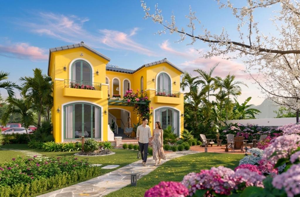 a man and woman walking in front of a yellow house at Plum Village Moc Chau in Mộc Châu