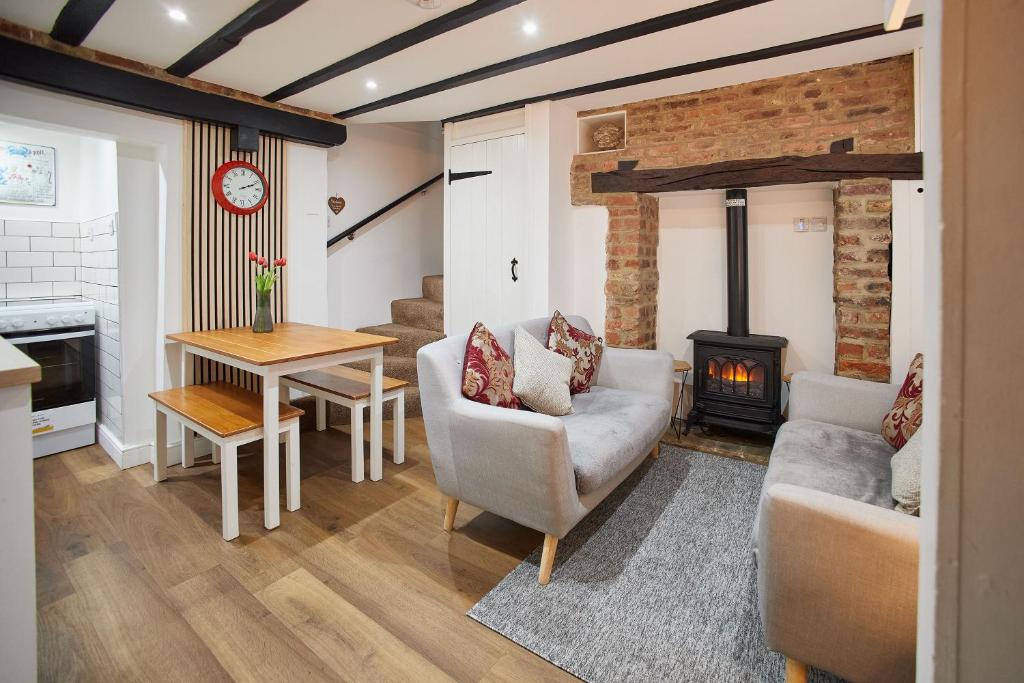 a living room with a couch and a fireplace at Host & Stay - Thimble Cottage in Whitby
