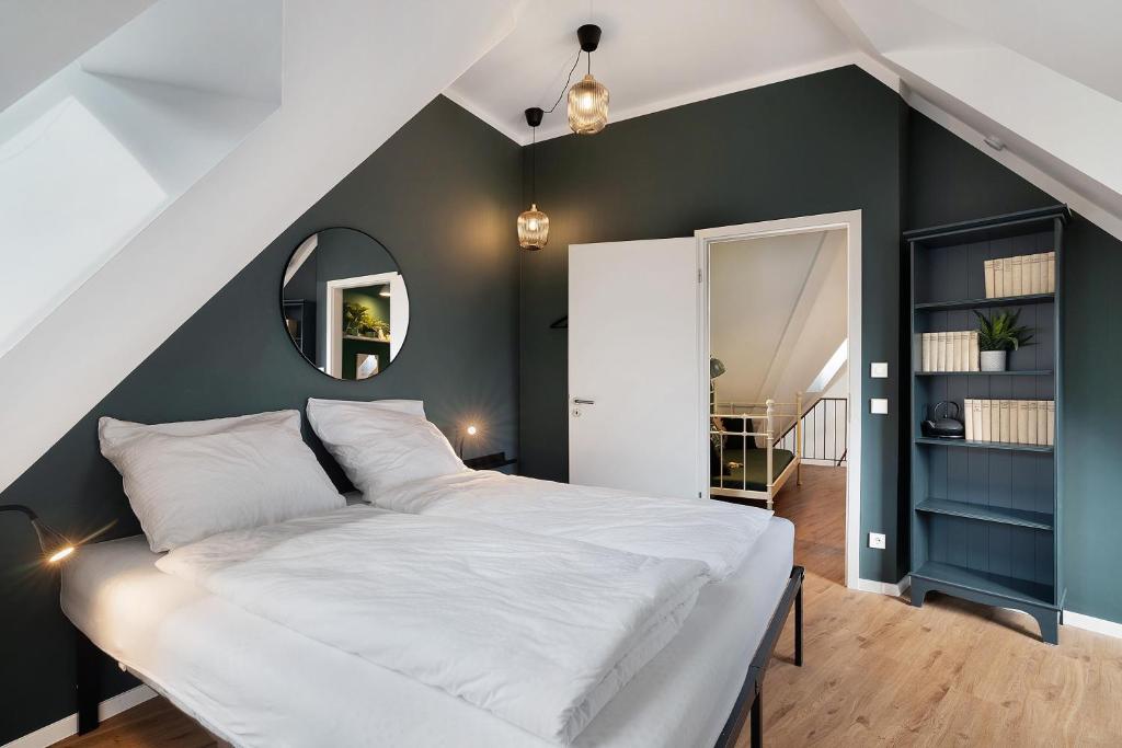 a bedroom with a white bed and a green wall at Remise im Wolkensteiner Hof in Gernsbach