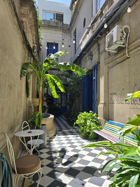 an alley with plants and a table and chairs at Meridiano Hostel Boutique in Buenos Aires