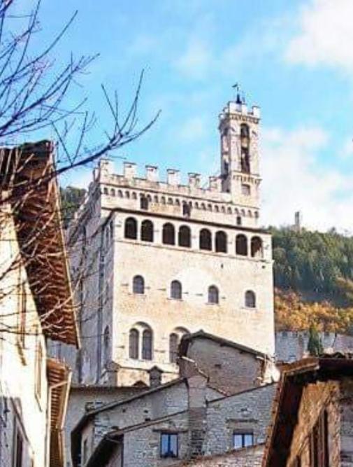 a large building with a clock tower on top of it at A Casa di Cristina in Gubbio