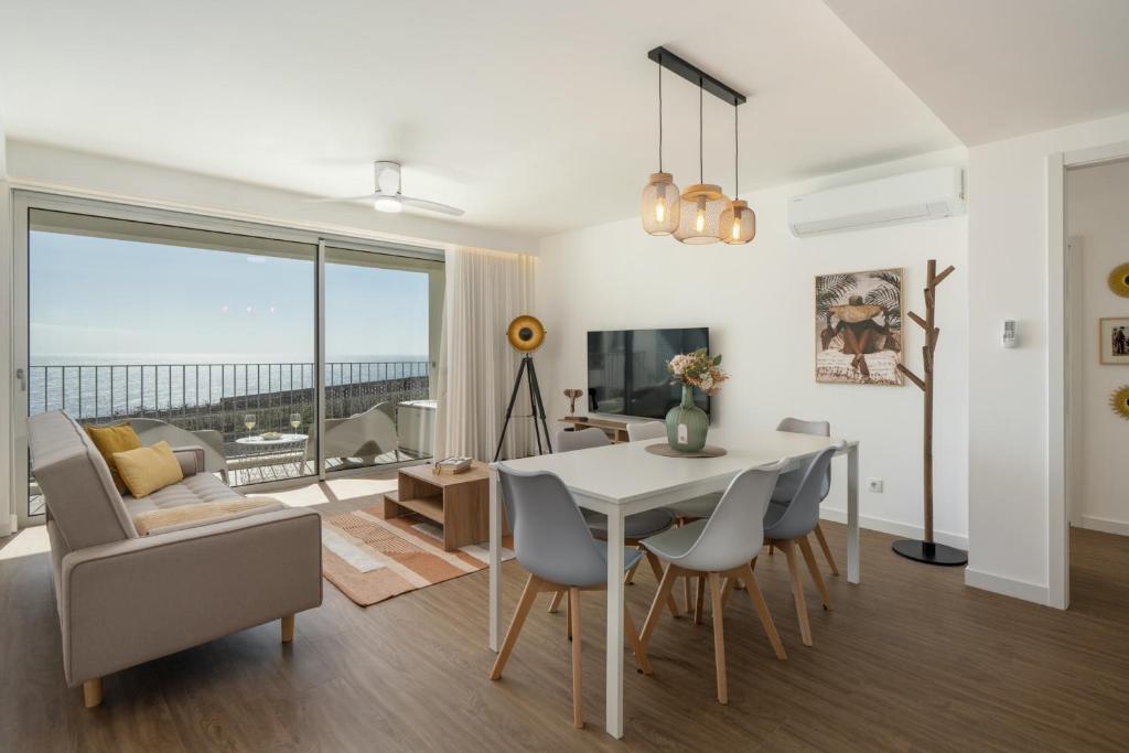 a dining room and living room with a table and chairs at BAsia Apartment by An Island Apart in Funchal
