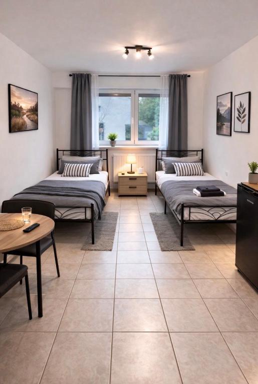 a bedroom with two beds and a table at Monteurzimmer Saarland in Merchweiler