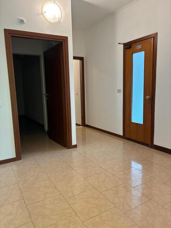 ein leerer Raum mit einer Tür und einem Fliesenboden in der Unterkunft Hotel Riccò in Bagnolo San Vito