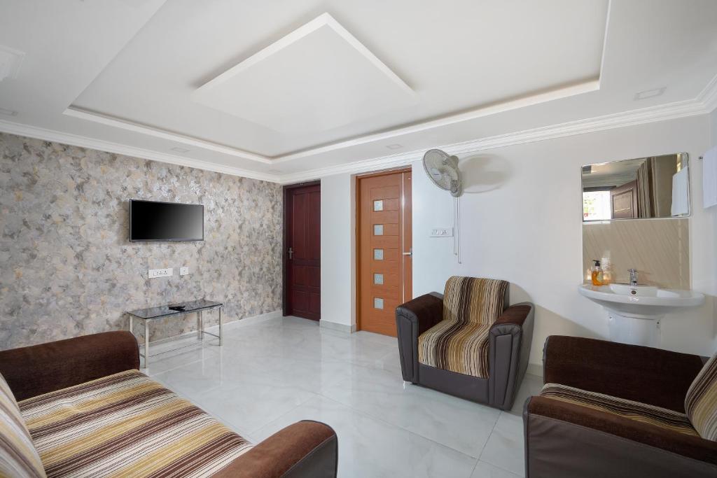a living room with two chairs and a sink at BHRS Residency in Munnar