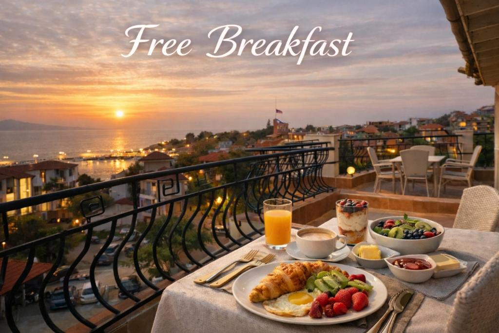 a breakfast table on a balcony with food and juice at HOUSEDENz in Chernomorets