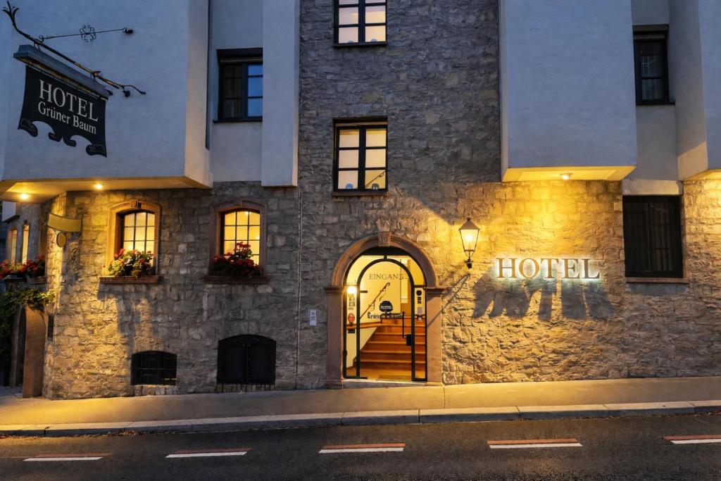 ein Hotel mit einem Hotelschild an der Seite eines Gebäudes in der Unterkunft Hotel Grüner Baum in Würzburg