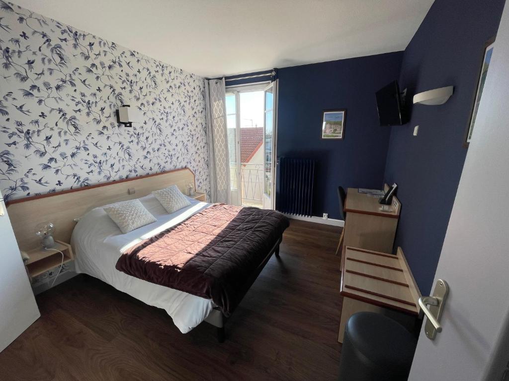 a bedroom with a bed and a blue wall at "Contact Hôtel" Le Saint Rémy - Chalon Sud in Saint-Rémy