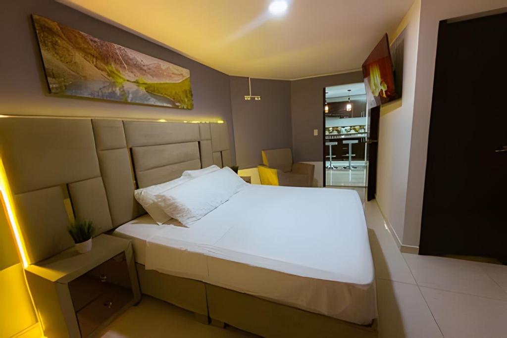 a bedroom with a large white bed in a room at amplio y lujoso apartasuite en el centro in Cartago