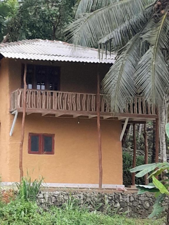 a house with a balcony on top of it at Morakanda Estate in Kahaduwa