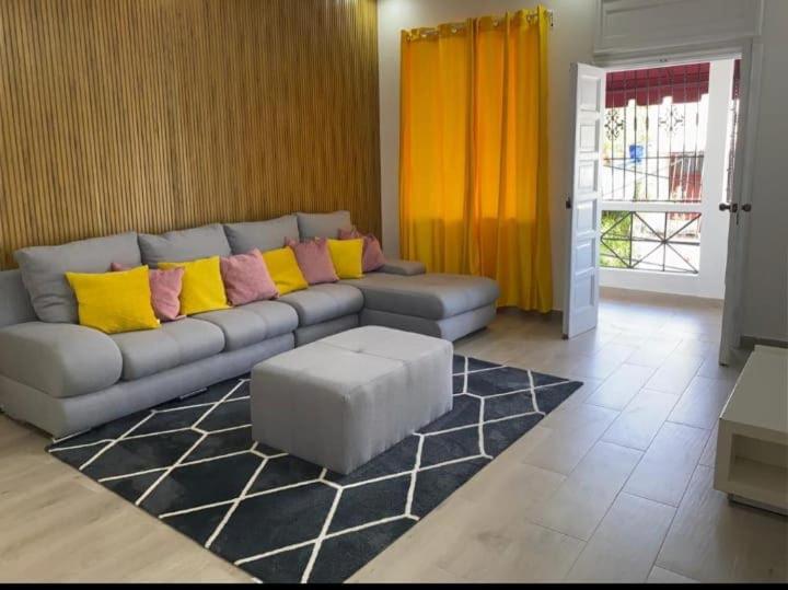 a living room with a couch with yellow and pink pillows at Apartamento-2B-Zona-Colonial in Santo Domingo