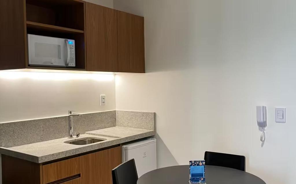 a kitchen with a sink and a table with chairs at Gav Muro Alto Resort below average rate in Ipojuca
