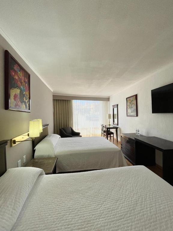 a hotel room with two beds and a flat screen tv at Arroyo Express in Zacatecas