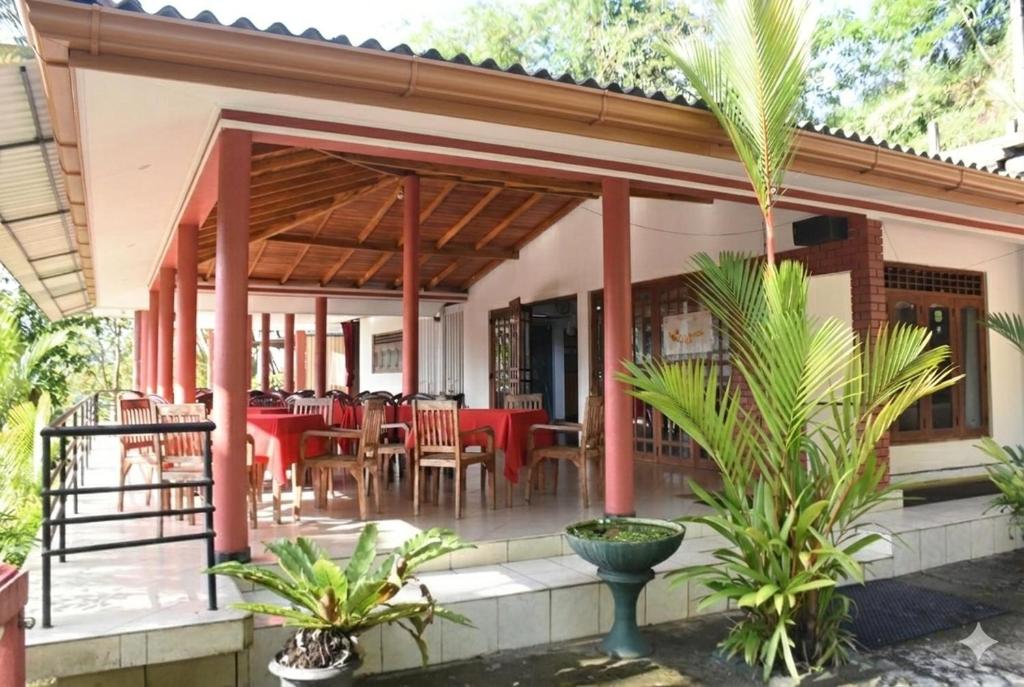 a restaurant with tables and chairs on a patio at Mount Crest Inn Deniyaya in Deniyaya