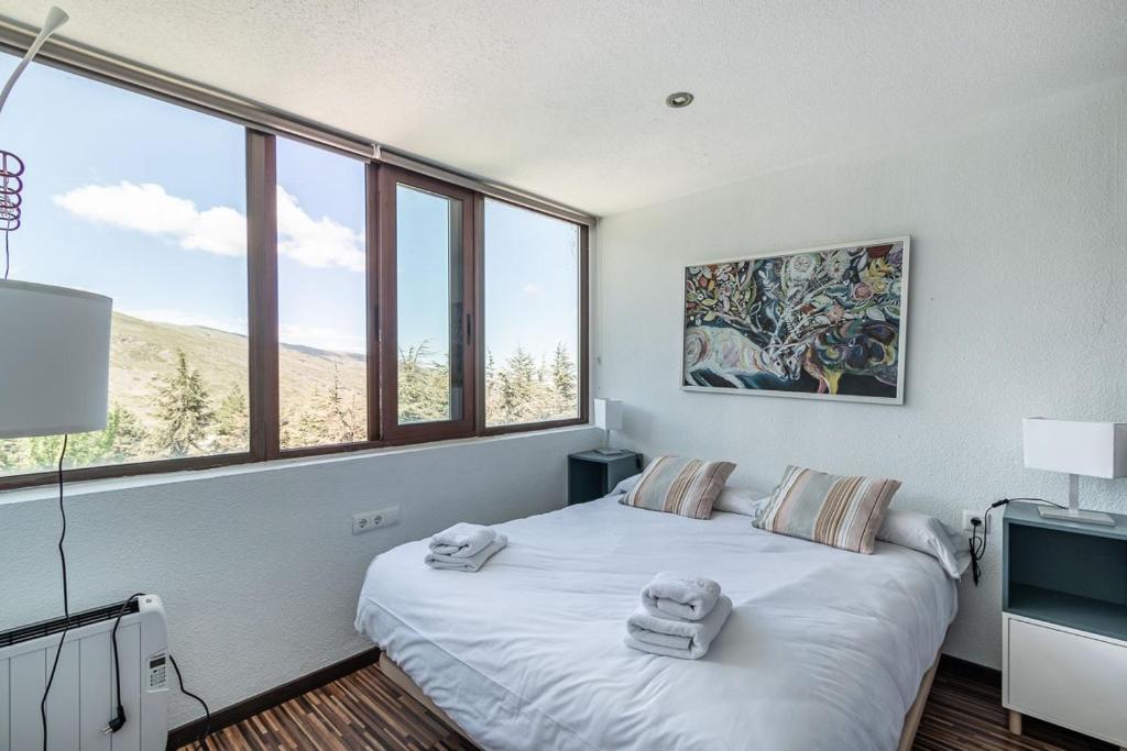 a bedroom with a large bed with towels on it at Sueño blanco in Sierra Nevada