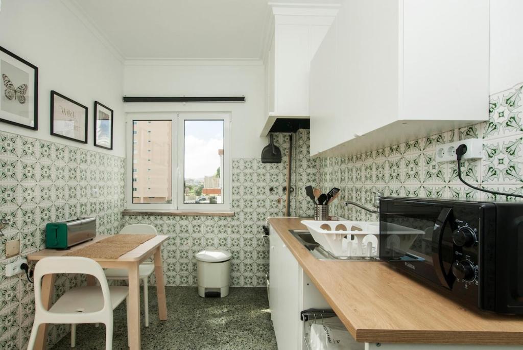 a kitchen with a table and a microwave at Low Cost University Privado in Lisbon