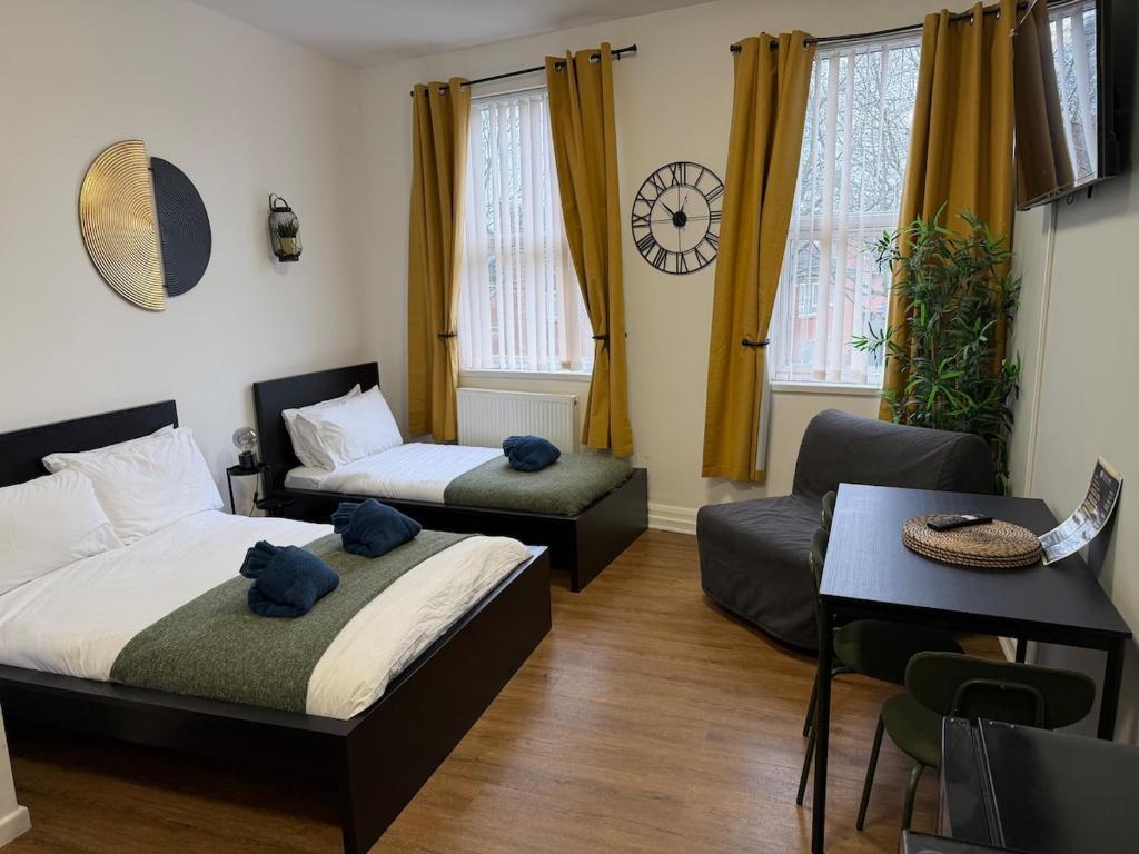 a bedroom with two beds and a couch and a table at City-Centre Studio · Self-Contained · Sleeps 3 in Nottingham