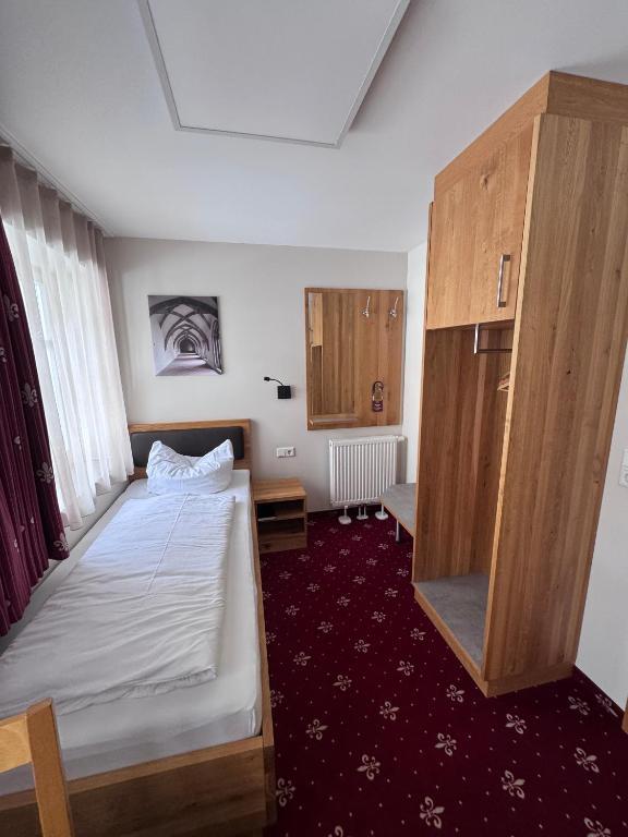 a small room with a bed and a cabinet at Einzelzimmer 9 in Heidenheim