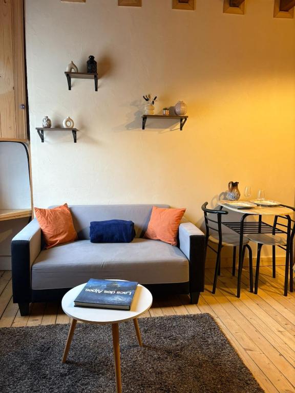 a living room with a couch and a table at Moulin de Noallie in Magland