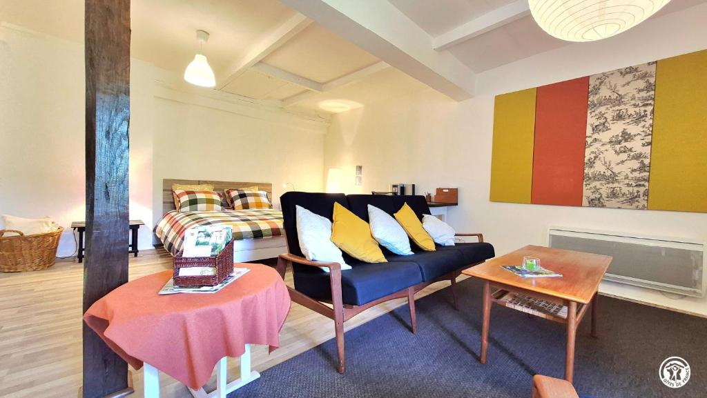 a living room with a couch and a bed at Les Hirondelles in Ouroux