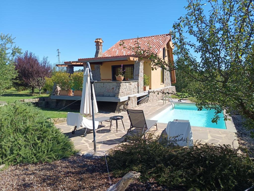 a house with a swimming pool and an umbrella at Chalet Melograno by Interhome in Sutri