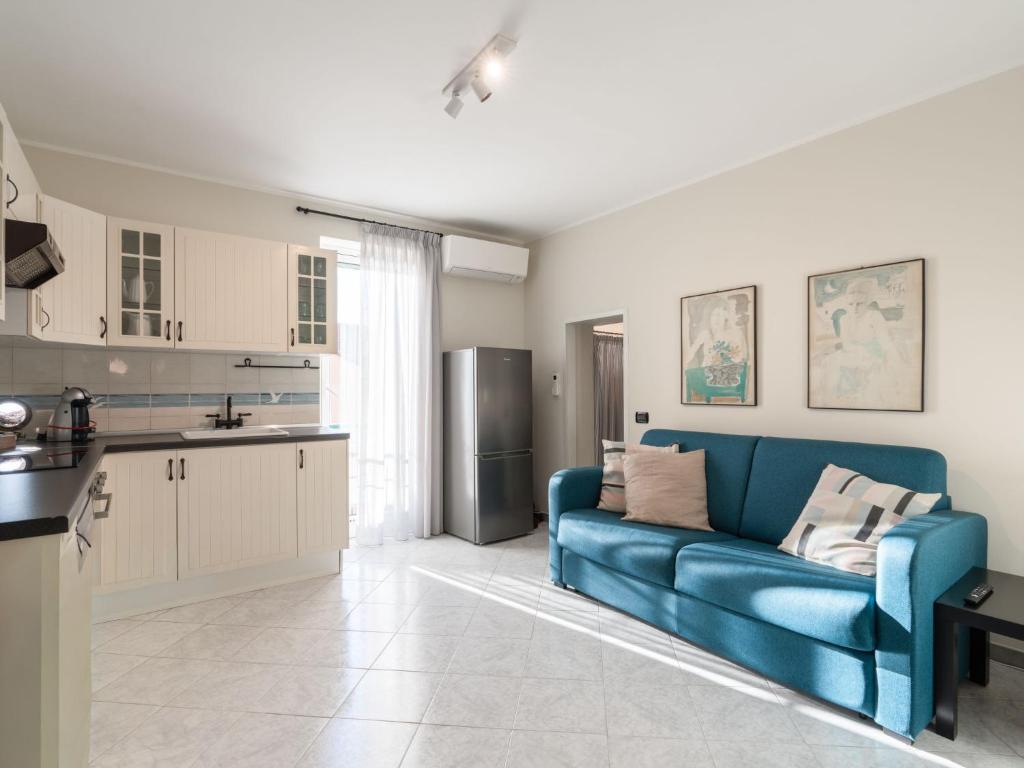 a living room with a blue couch and a kitchen at Apartment il Rifugio by Interhome in Bordighera