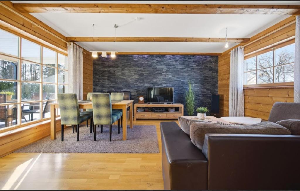 a living room with a couch and a table with chairs at Kasekuma House with all comforts well located in Otepää