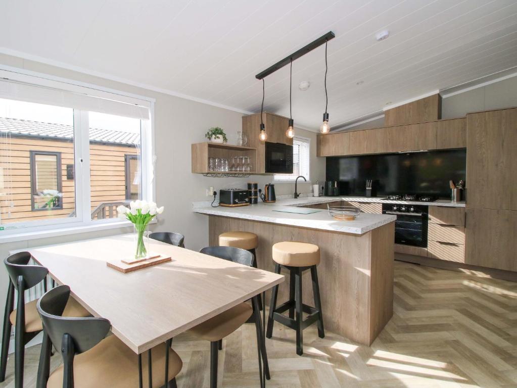 a kitchen with a table and some chairs and a counter at Tulip in Leominster