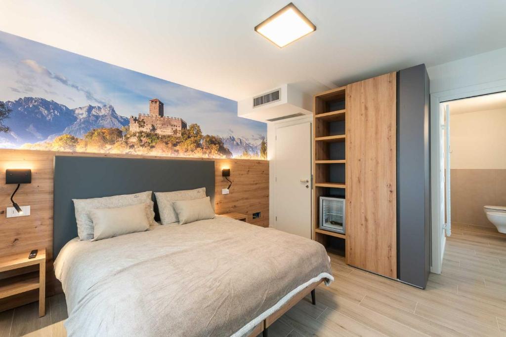 a bedroom with a bed with a painting on the wall at Relais del Borgo in Lentiai