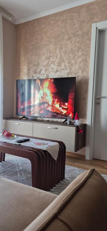 a living room with a large flat screen tv on a wall at Apartman Mikulic 2 in Subotica