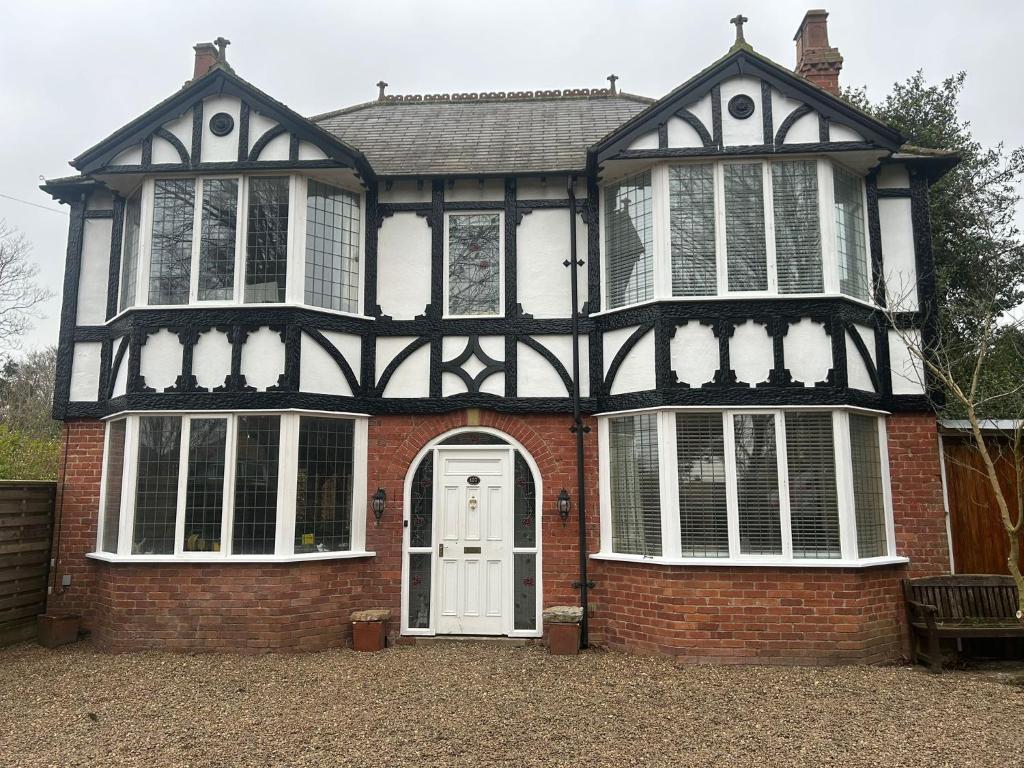 a large black and white house with a white door at Marton Lodge in Bridlington