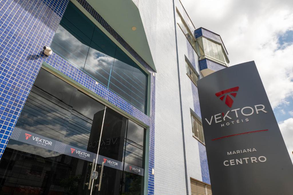 a building with a sign in front of it at Vektor Hotéis - Unidade Mariana in Mariana